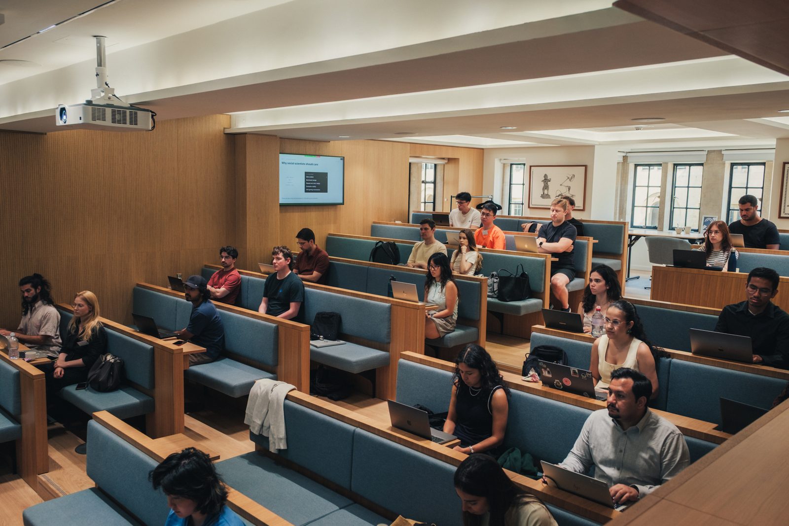 A lecture in progress in the Nuffield College lecture room, participants at laptops