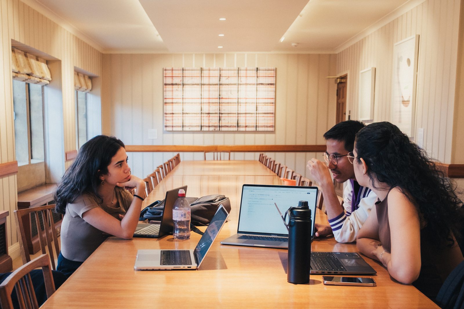 A team working together at a long table during an afternoon research session